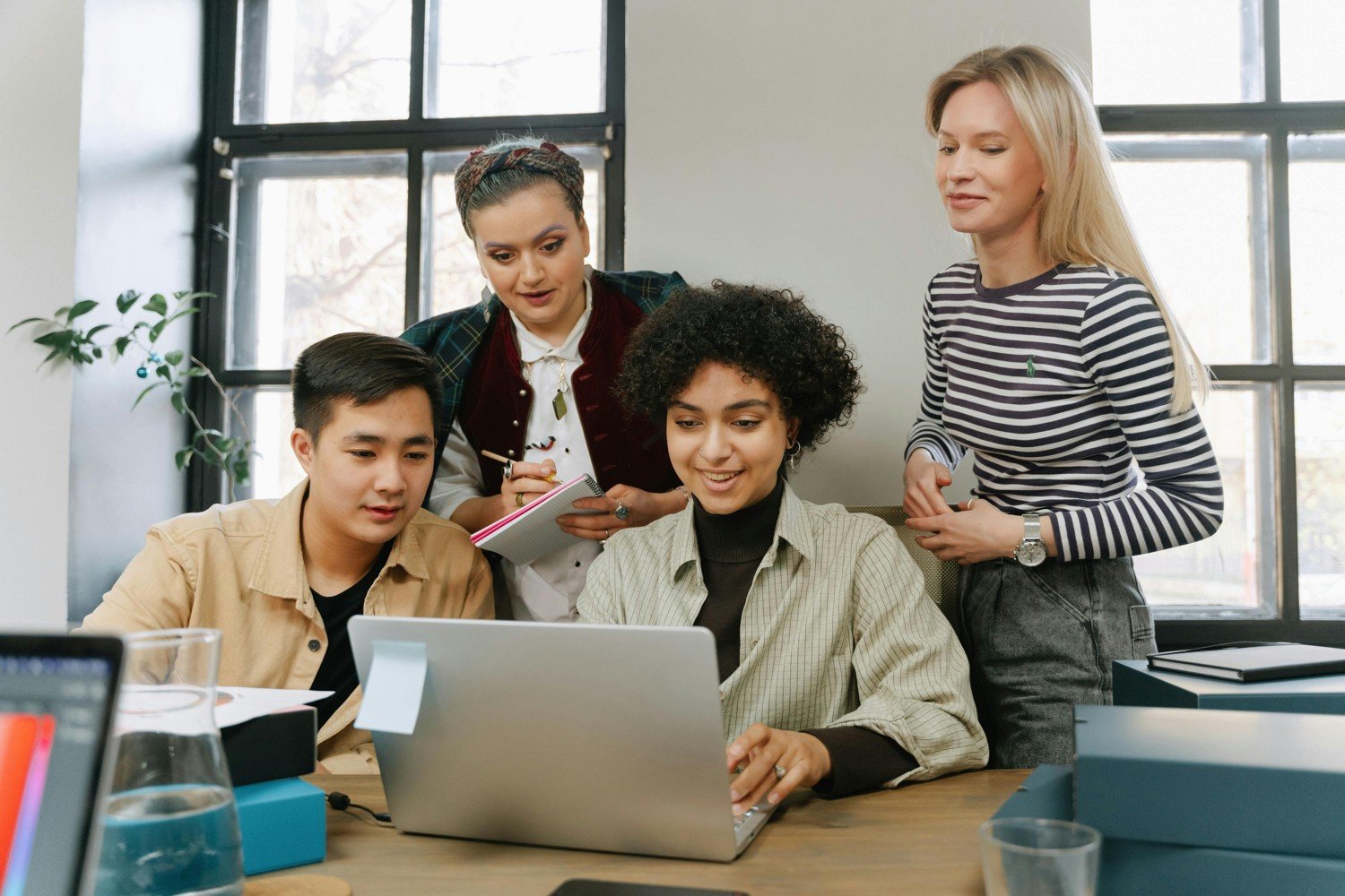 Group reviewing a laptop during a computer support discussion