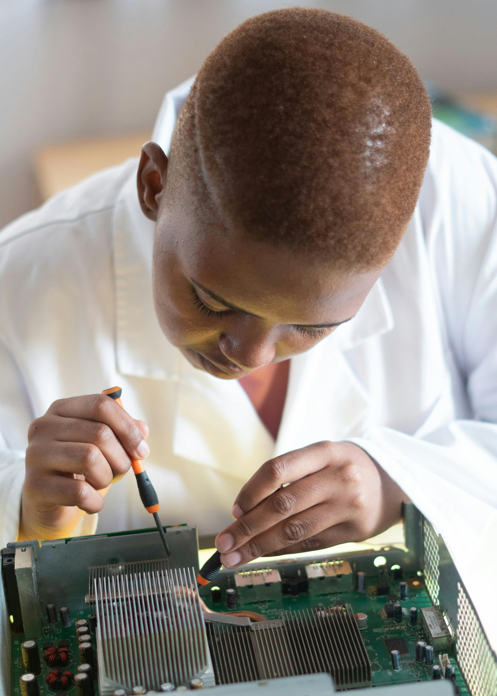 Technician using hand tools to inspect desktop computer hardware